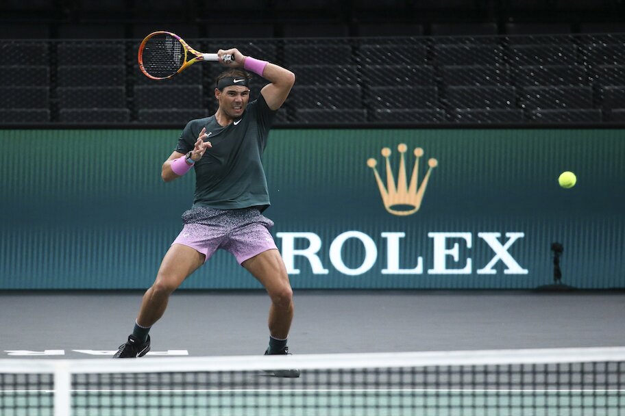 Rafael Nadal tennis player holding racket above head during rolex paris master