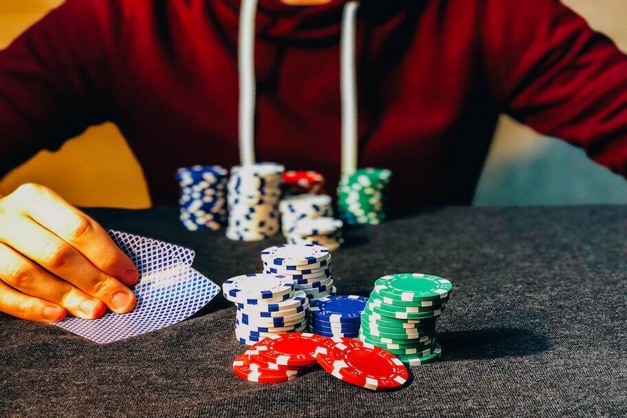 poker player peeking at cards with chips in front of him