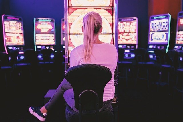 blonde woman gambling at slot machine